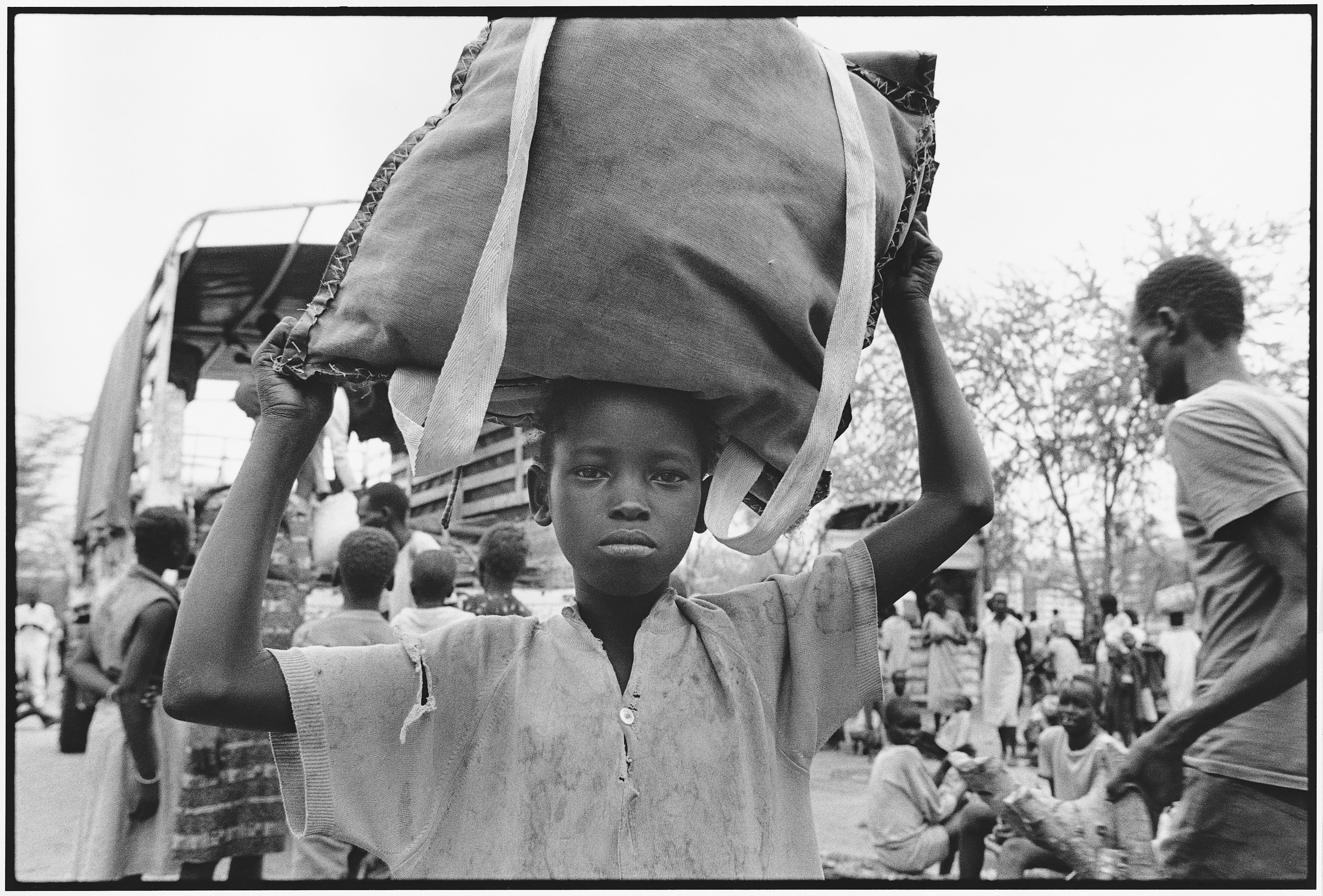 Credit: UNHCR/B.Press Caption: A young Dinka boy arriving in Kenya in 1992. Determined to get an education, many of the "Lost Boys" carried books with them across hundreds of miles of desert.